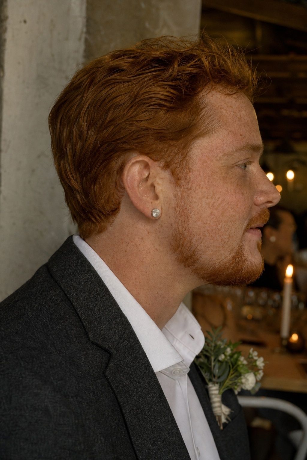 Brushed silver stud earrings with a charcoal suit