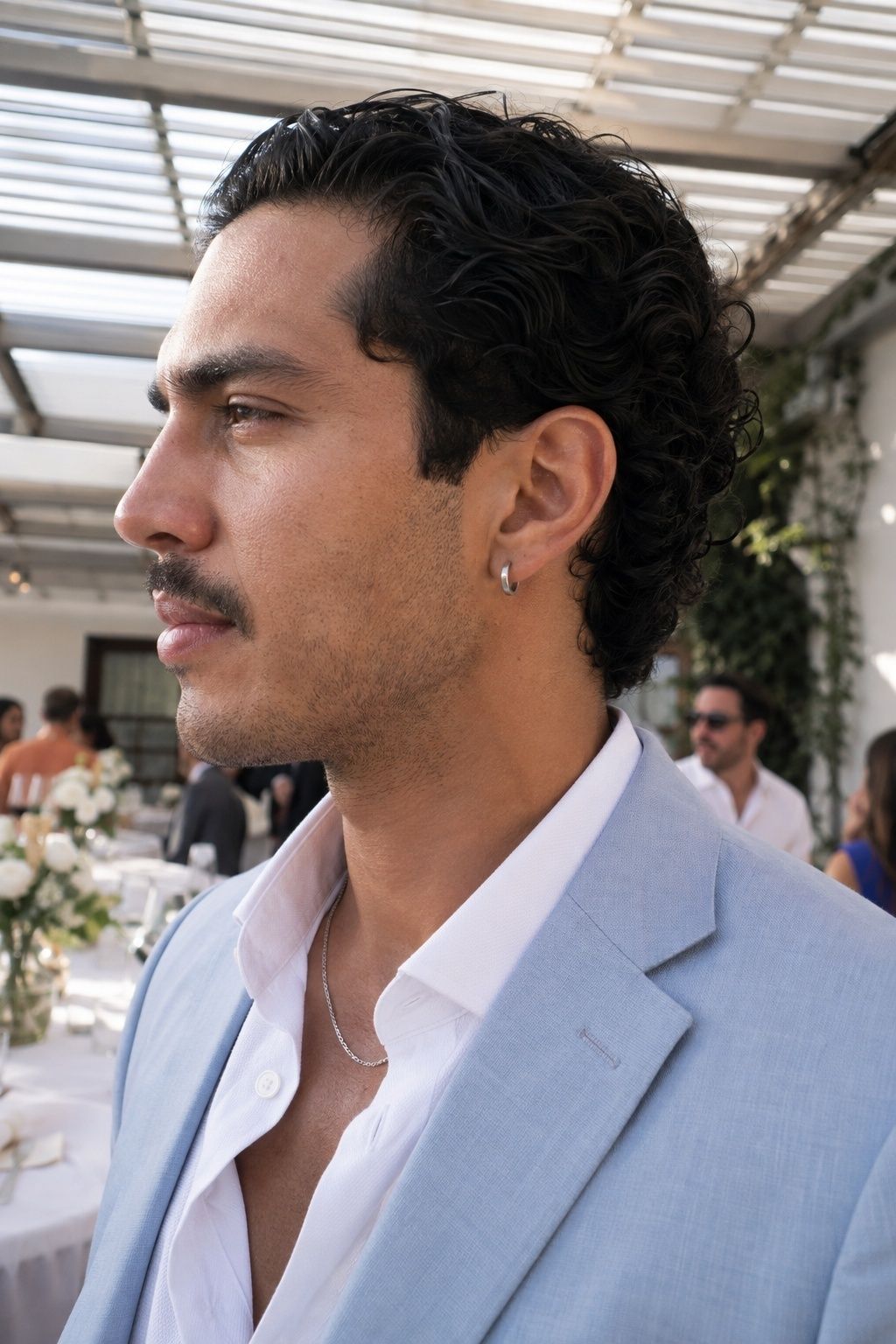Silver huggie earrings with an open-collar shirt
