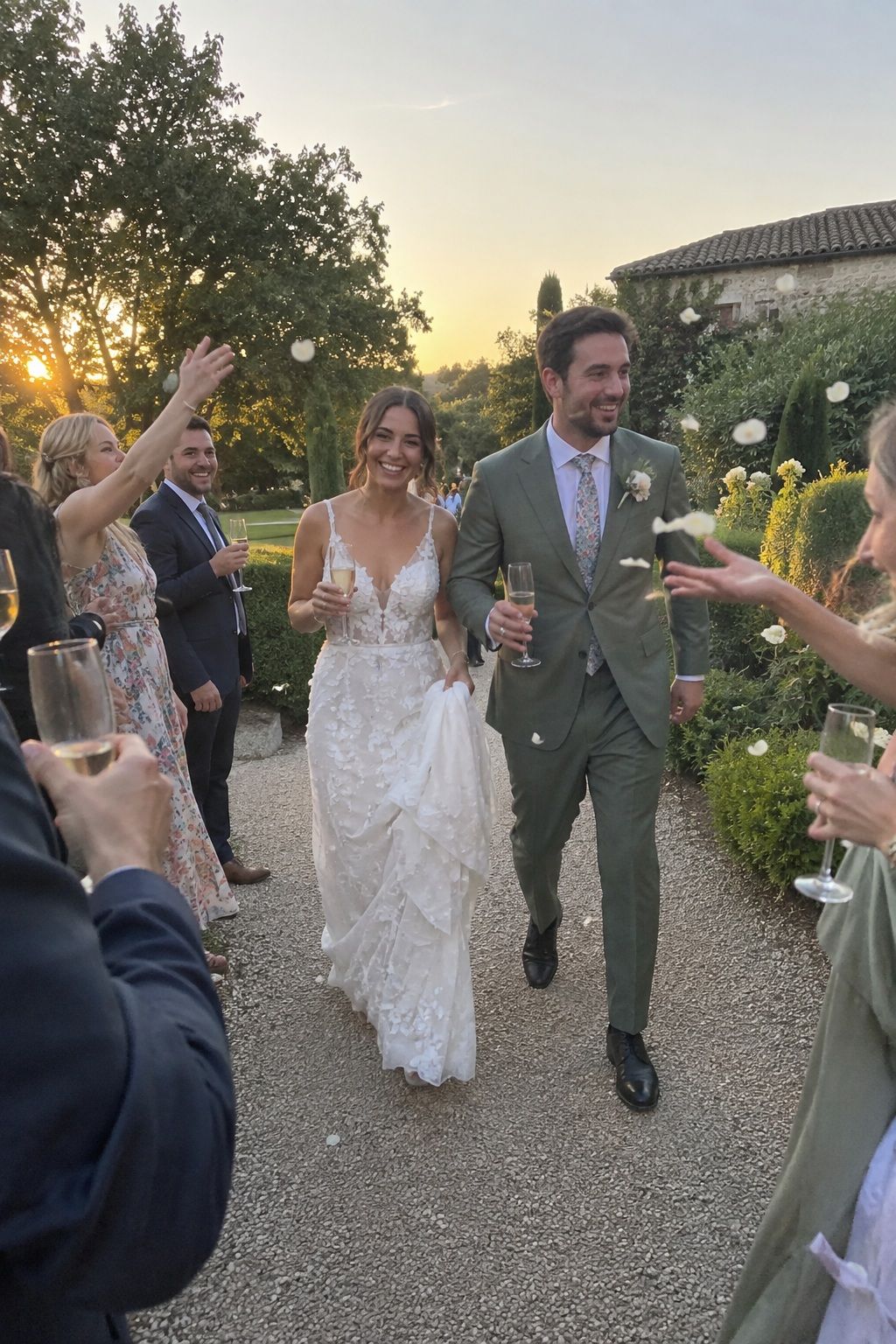 Newlyweds walking through a candid golden-hour petal toss and champagne toast