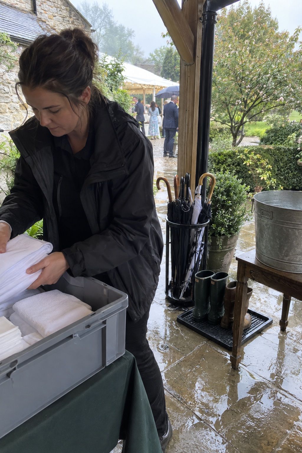 Coordinator organizing towels, umbrellas, and boot trays for wet spring weather