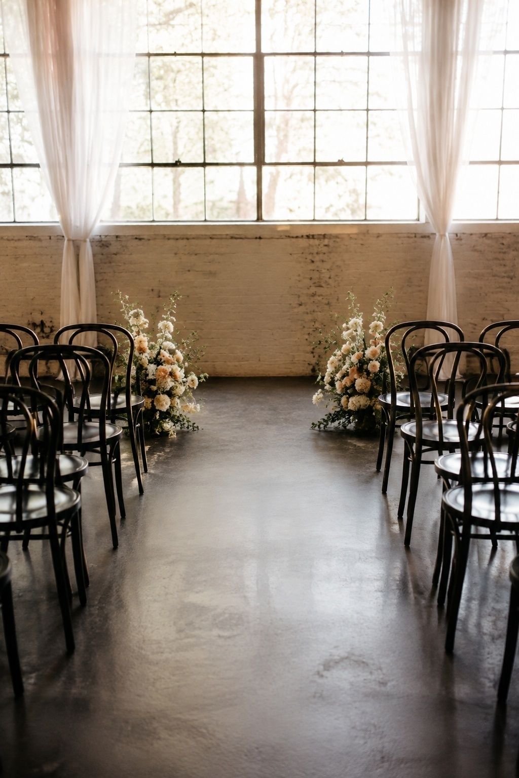 Eye-level view from the back of a short indoor ceremony aisle with three rows of chairs per side