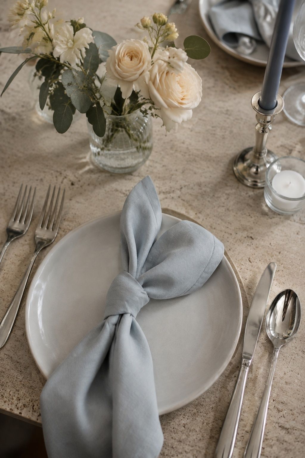 Powder blue napkin with buttercream flowers and silver flatware