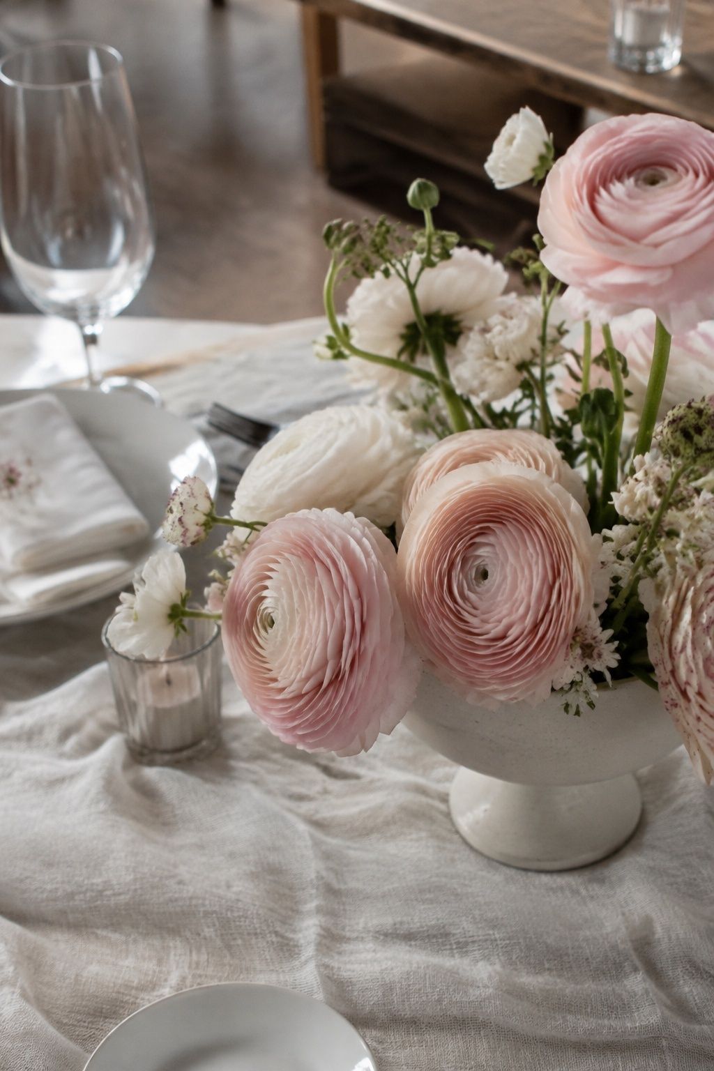 Blush ranunculus with layered petals in a petite cream compote.