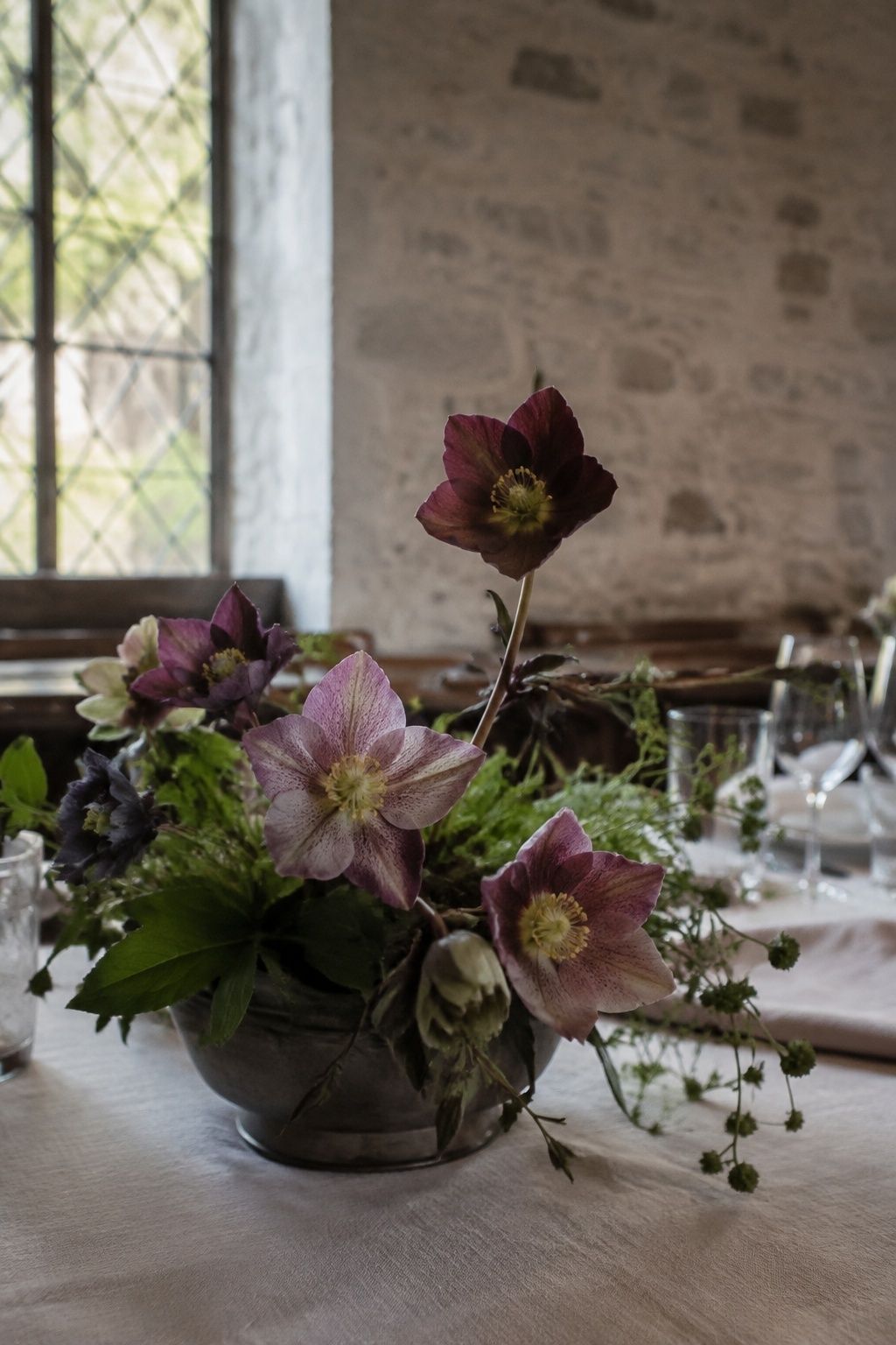 Plum and mauve hellebores in a low pewter wedding centerpiece.