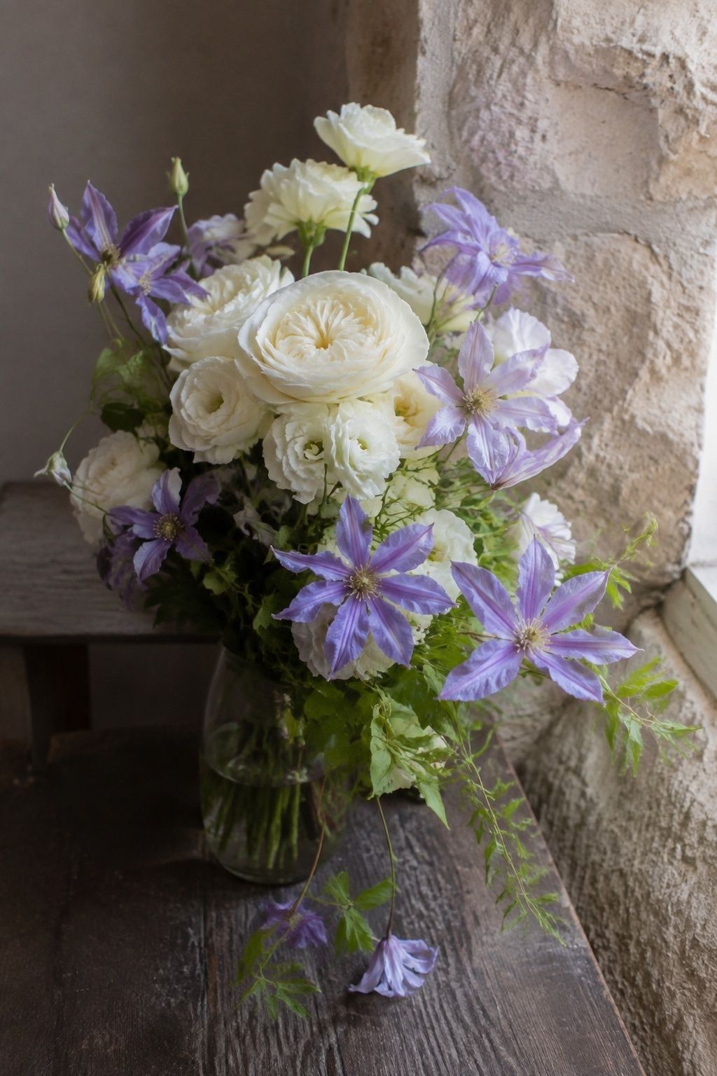 Lavender clematis trailing from an ivory bridal bouquet.