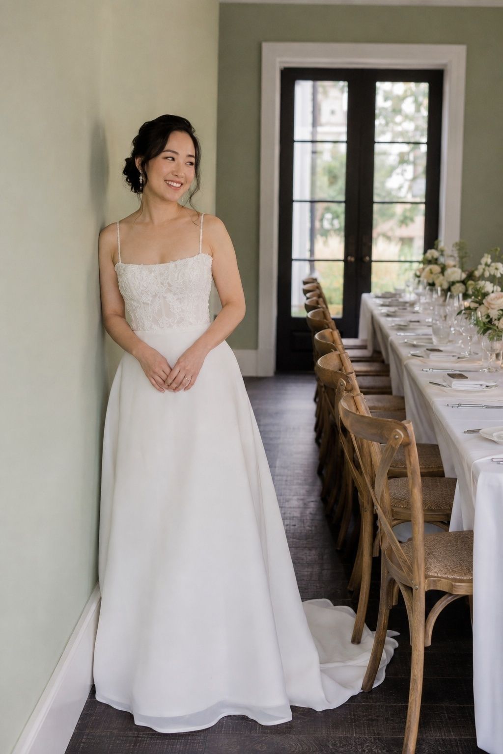 Bride in a delicate lace square-neck A-line gown beside an intimate dinner table