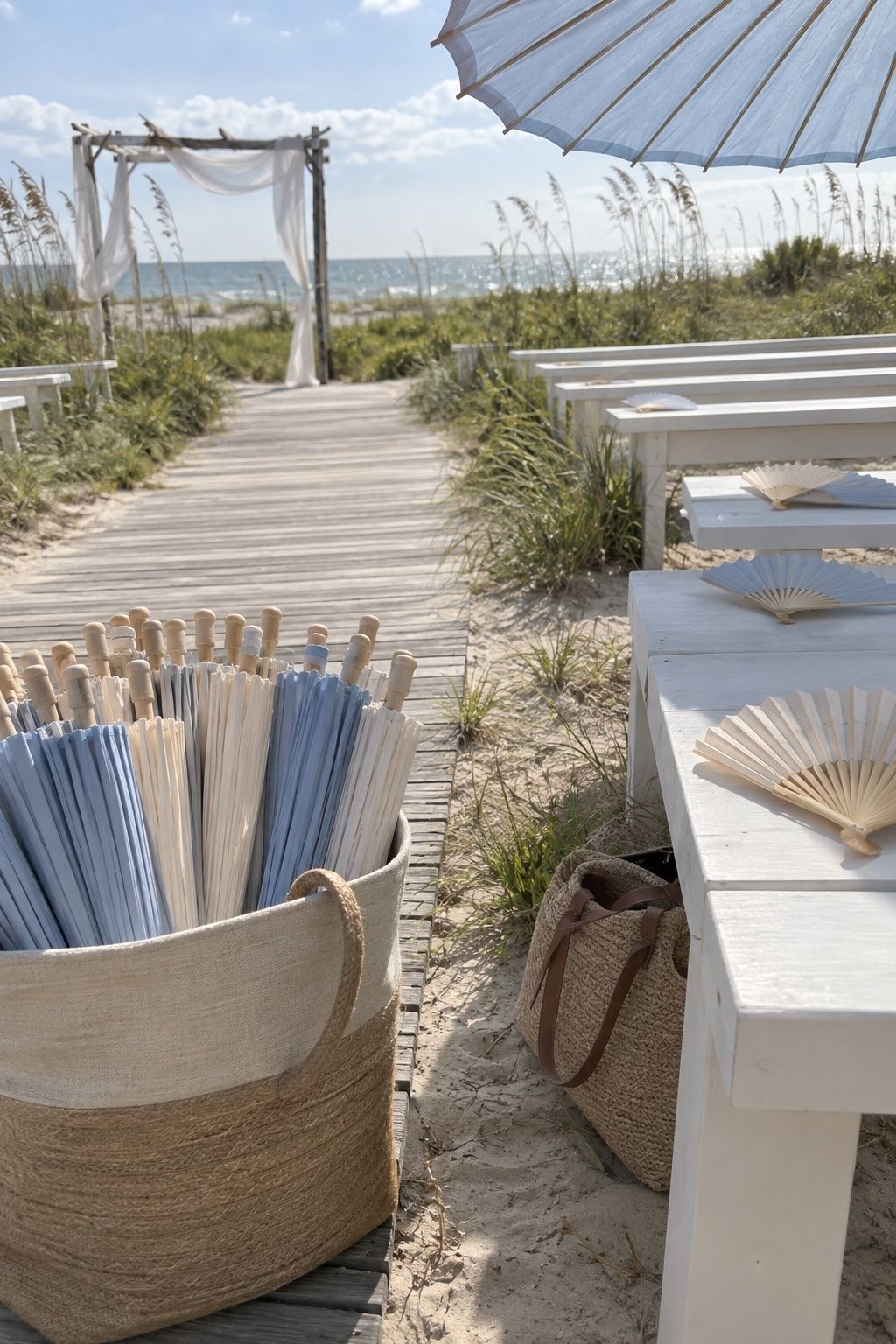 Cream and pale blue parasols with paper fans at a small beach wedding ceremony