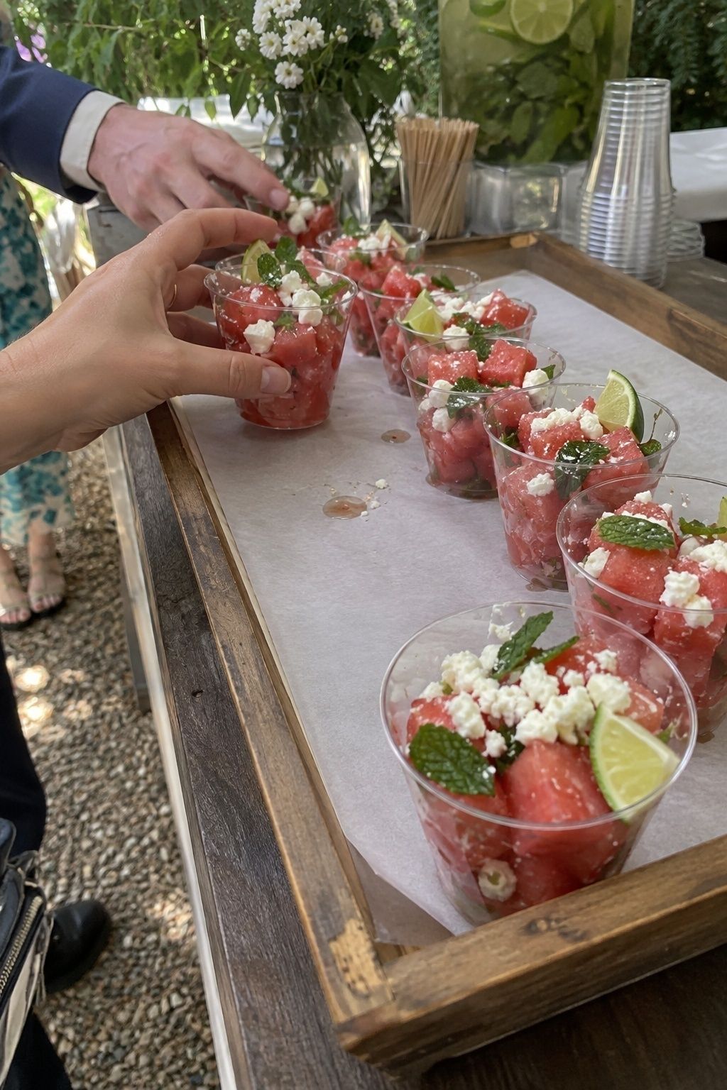 Individual watermelon feta mint cups at a shaded summer wedding bar
