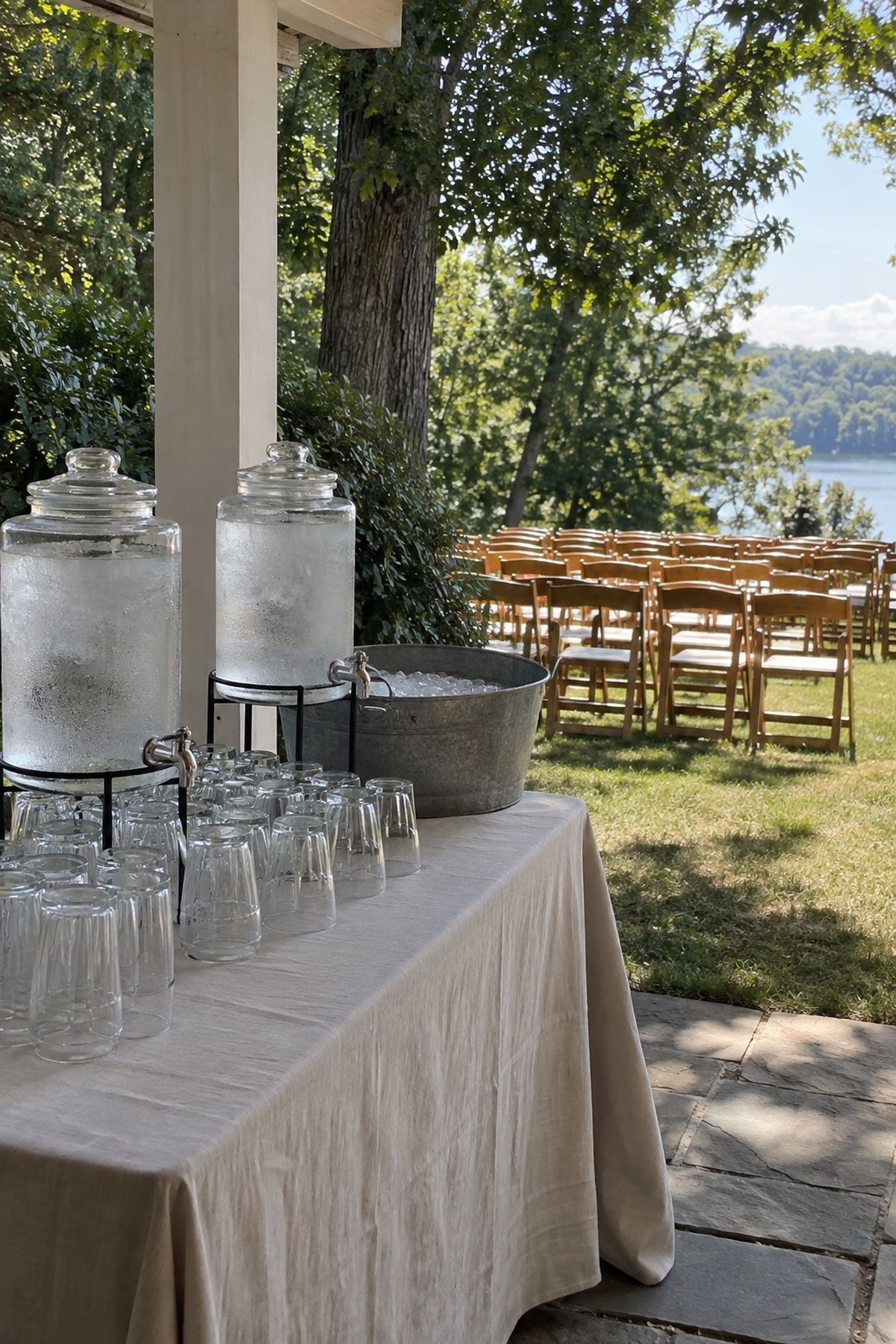Shaded water station along the guest route to a summer wedding ceremony