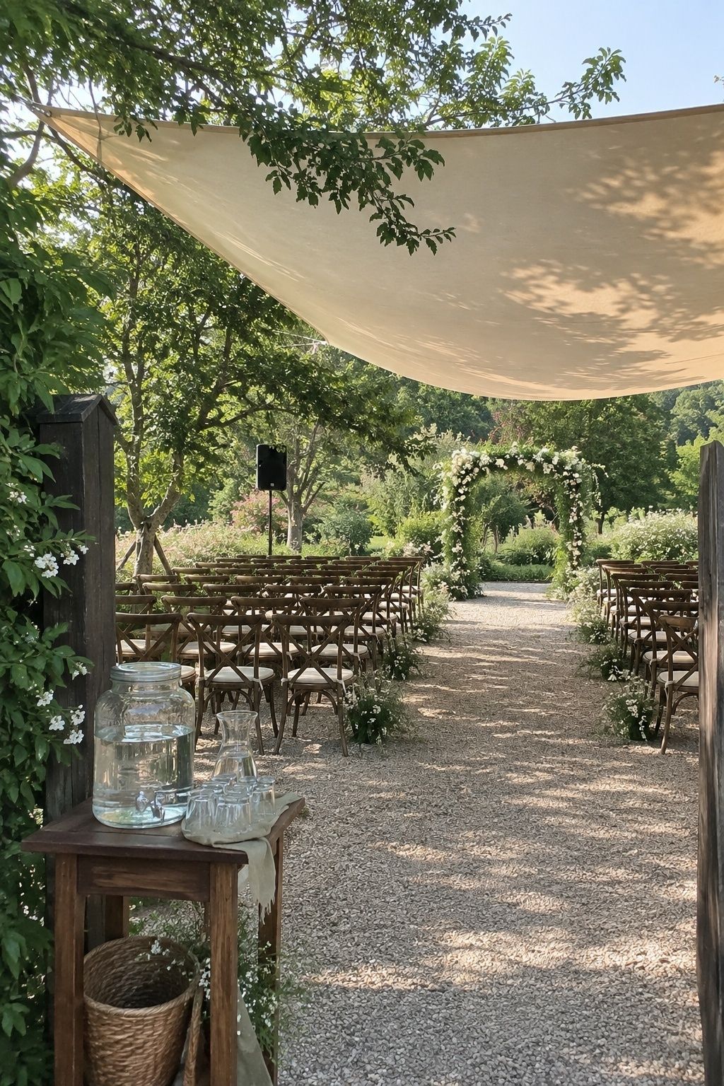 Shaded outdoor ceremony with water, spaced chairs, a clear aisle, and sound for guest comfort