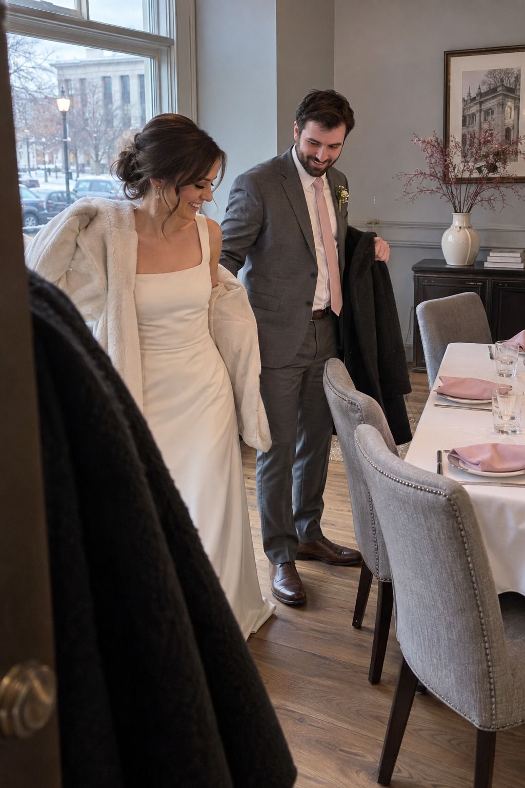 Newlyweds arrive at a small restaurant reception with soft-pink napkins, cool-gray chairs and ivory linen.