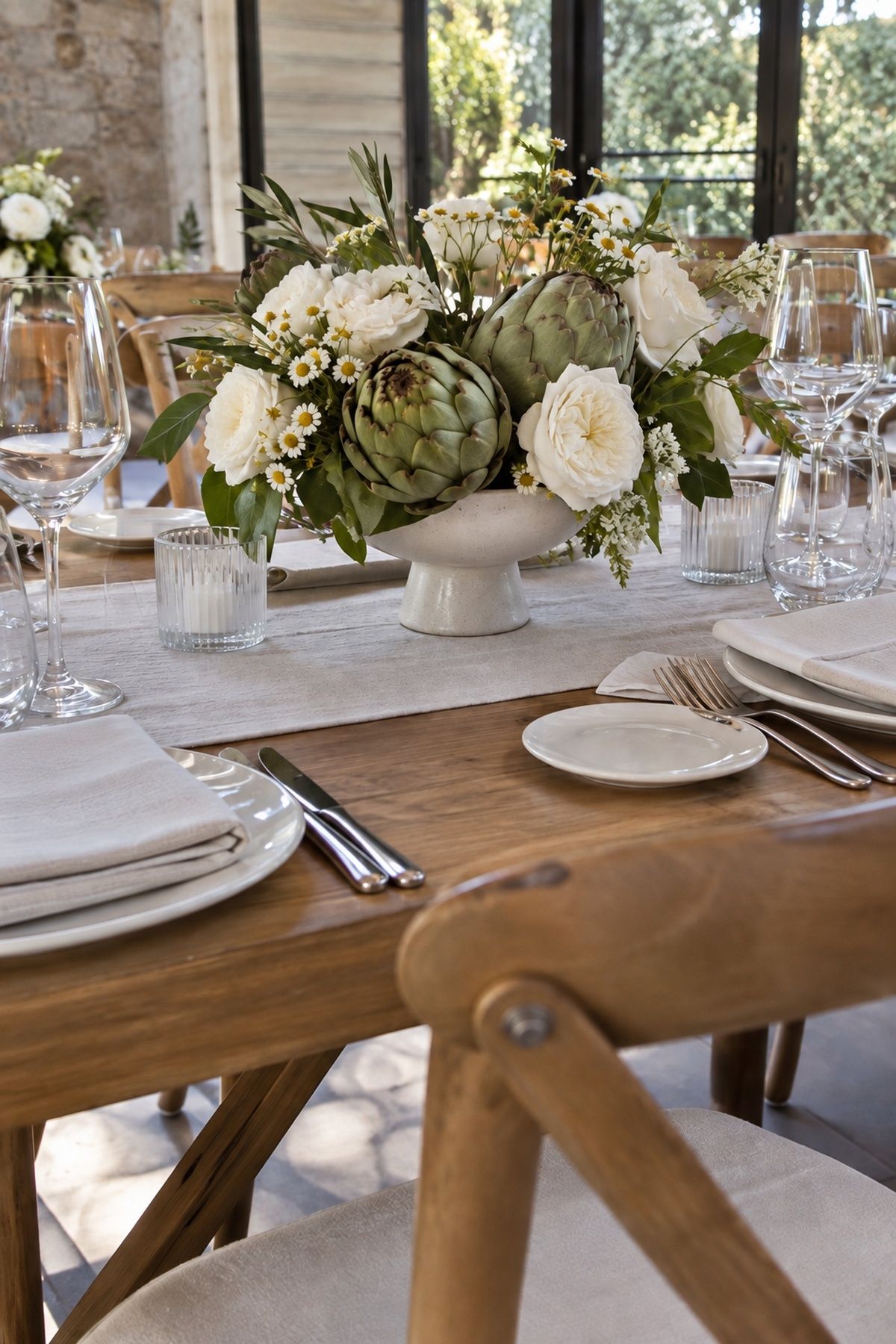 Artichokes and white flowers in a low compote for an intimate wedding table