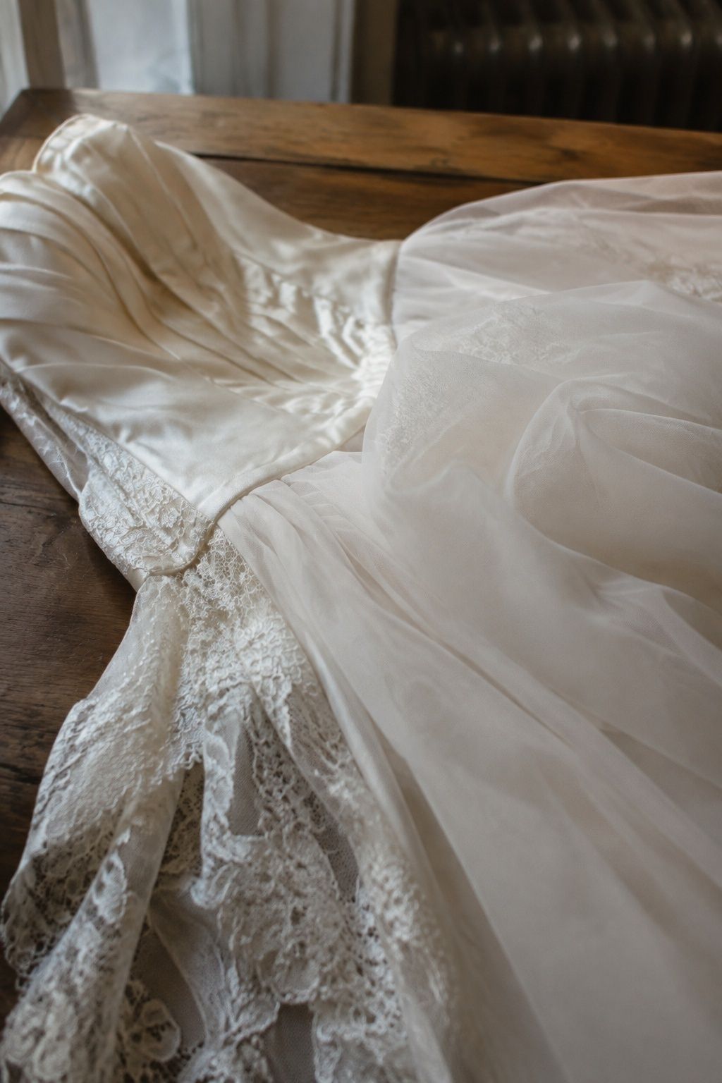 Close view of ivory satin, organza and lace on a bridal gown
