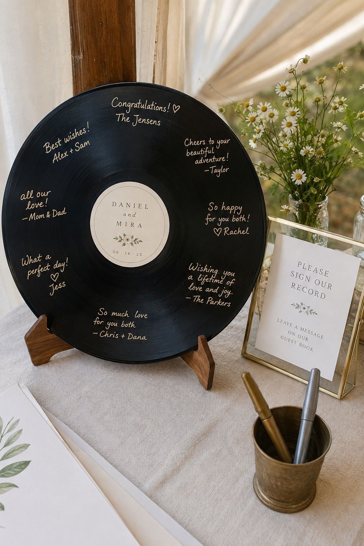 Signed vinyl record wedding guest book with gold messages, paint pens, flowers, and instruction card