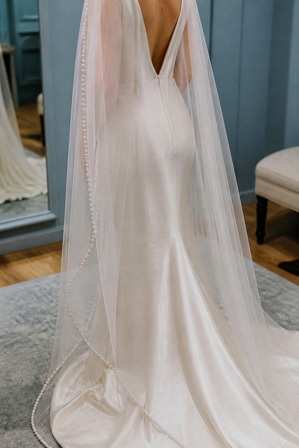 Pearl-trimmed cape with a minimal satin gown