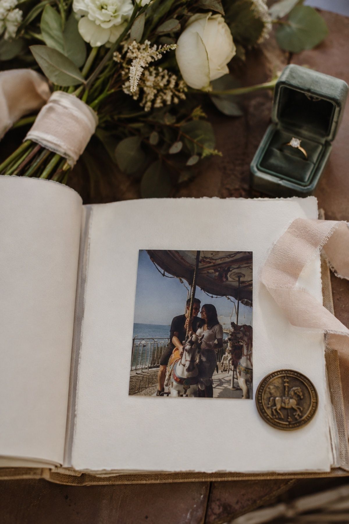 Personal carousel memory displayed in a wedding photo album with a vintage token