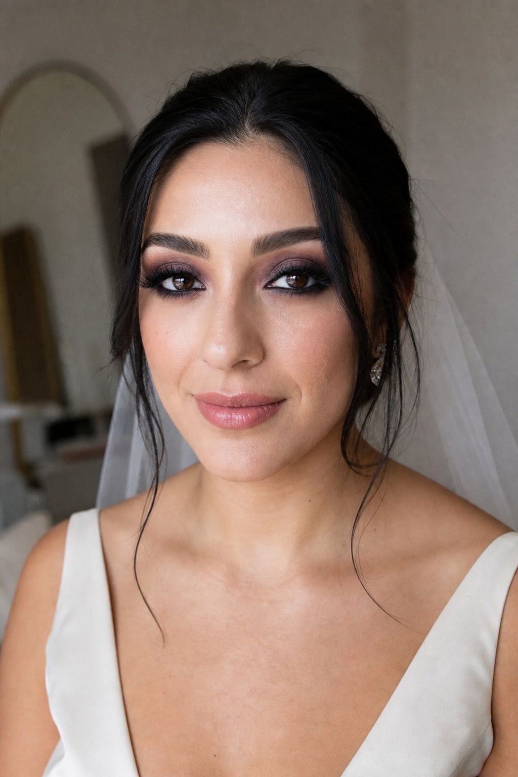 Bride wearing dramatic plum smokey eyes with a soft rose lip.