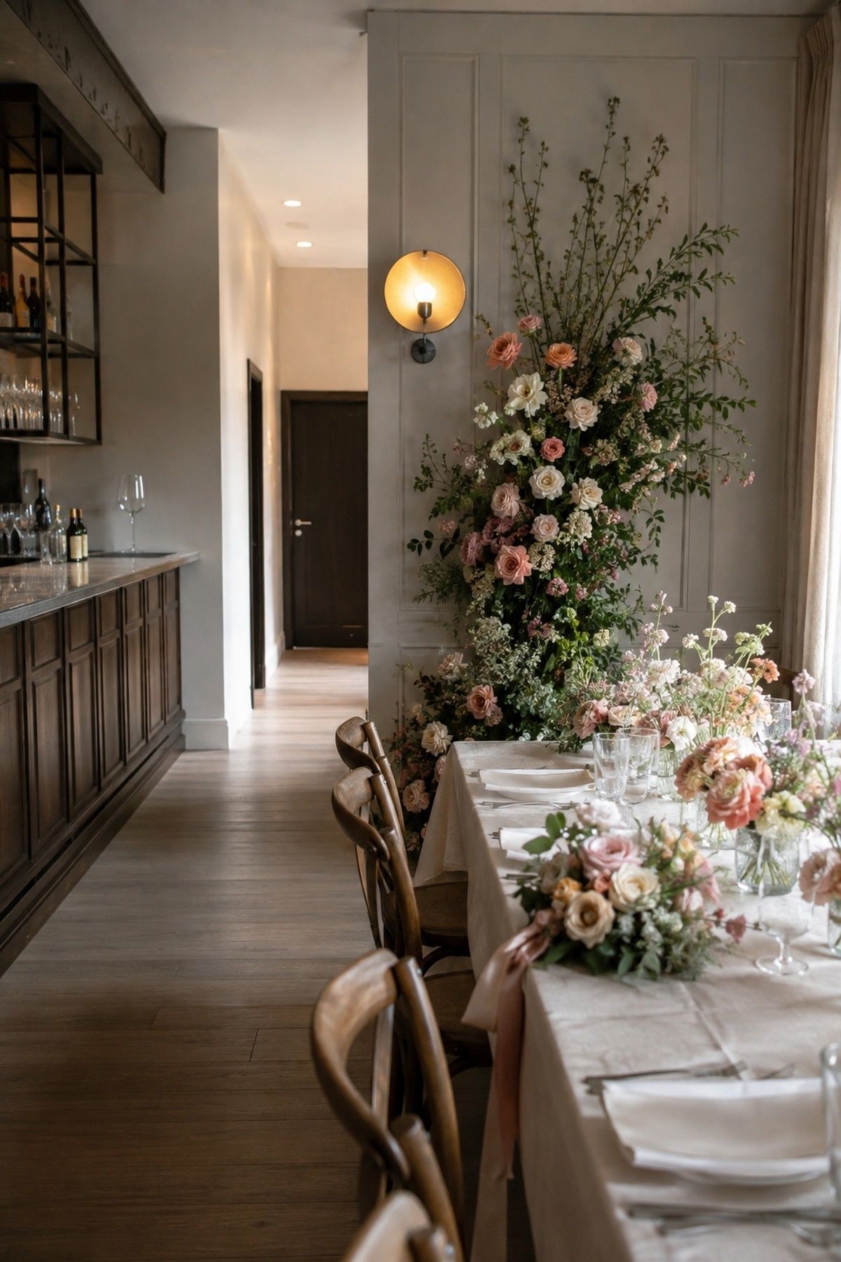 Intimate wedding dinner with flowers concentrated at one focal table and a clear undecorated bar