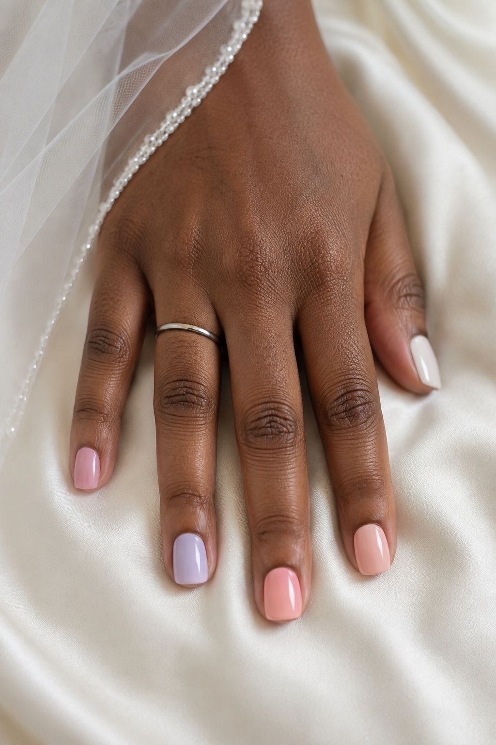 Glossy mismatched bridal nails in blush, lilac, peach and ivory