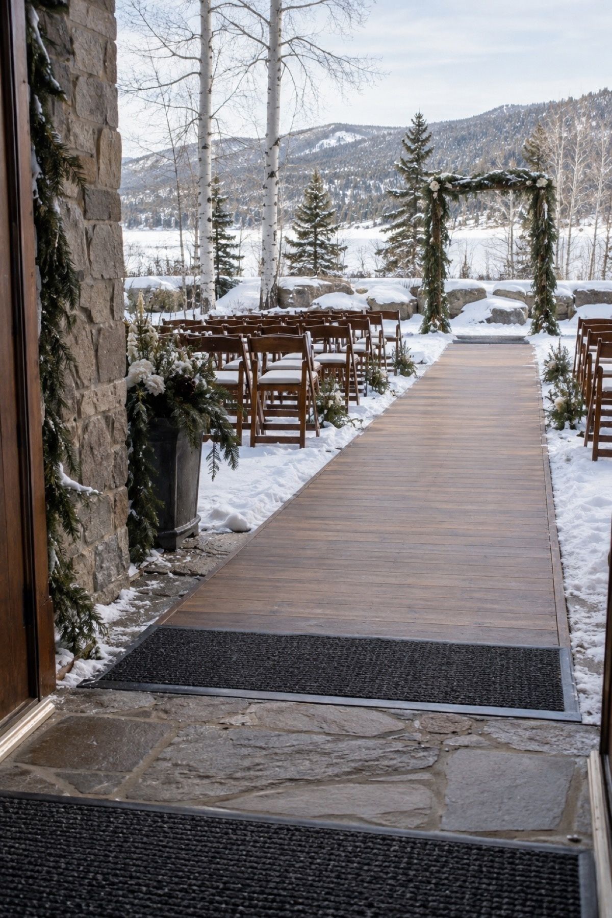 Firm temporary flooring and non-slip mats on a snowy outdoor wedding aisle